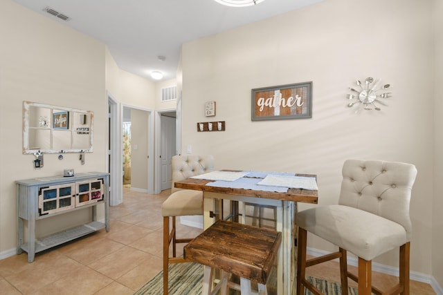 dining area with light tile patterned floors, visible vents, and baseboards