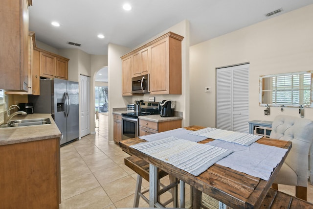 kitchen featuring stainless steel appliances, light countertops, a sink, and visible vents