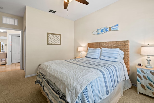 bedroom featuring baseboards, ceiling fan, visible vents, and light colored carpet