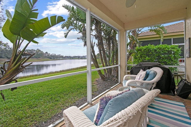 sunroom with a water view and a ceiling fan