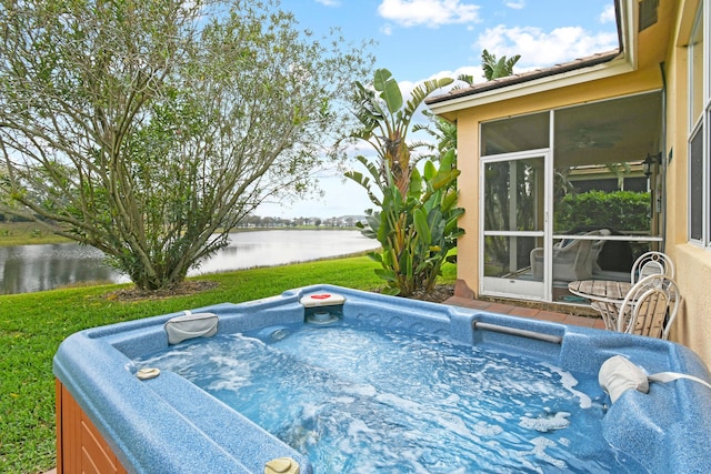 view of swimming pool featuring a water view, a sunroom, a hot tub, and a lawn