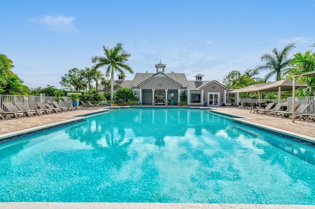 pool with a patio area and fence