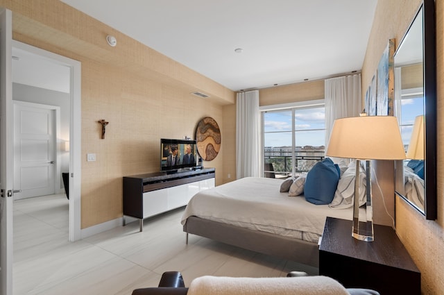 bedroom featuring visible vents, baseboards, and wallpapered walls