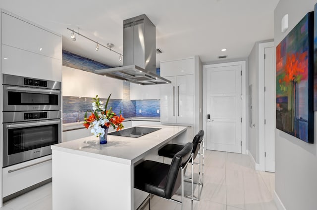 kitchen featuring island range hood, modern cabinets, a kitchen island, and a breakfast bar area