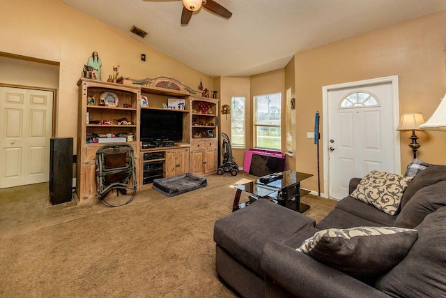 living room featuring lofted ceiling, dark colored carpet, ceiling fan, and visible vents