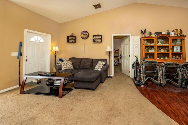 carpeted living room with lofted ceiling, visible vents, and baseboards