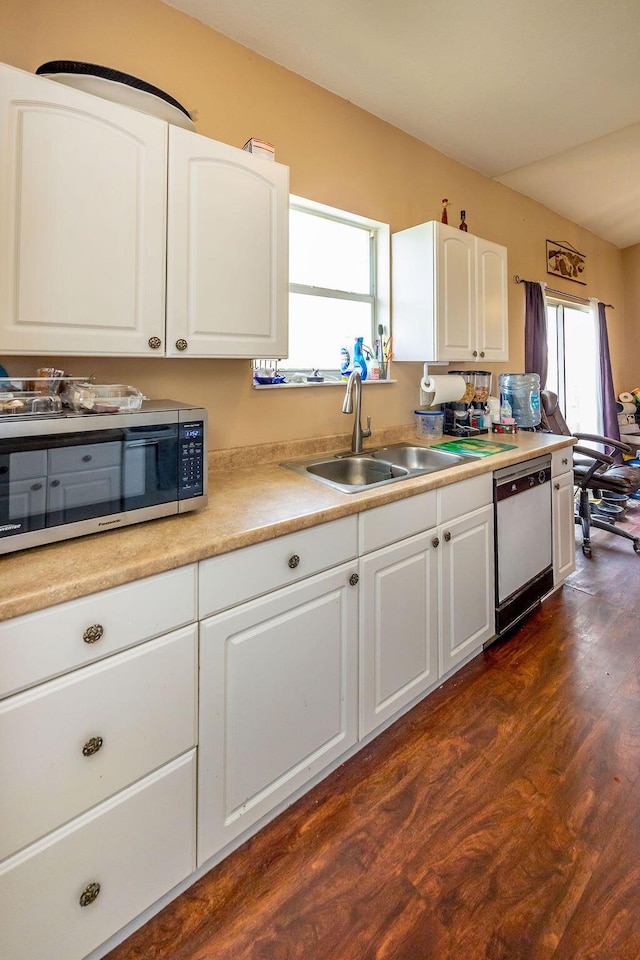 kitchen featuring dark wood finished floors, light countertops, stainless steel microwave, white cabinets, and white dishwasher