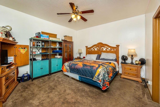 bedroom featuring ceiling fan, dark carpet, and a textured ceiling