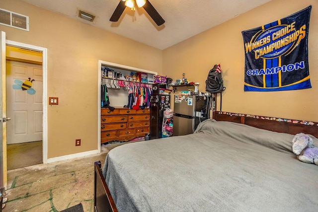 bedroom featuring visible vents, ceiling fan, a closet, and freestanding refrigerator