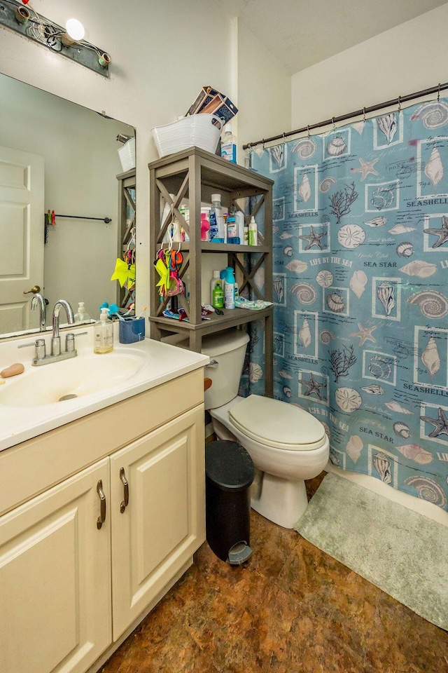 bathroom with a shower with shower curtain, vanity, and toilet