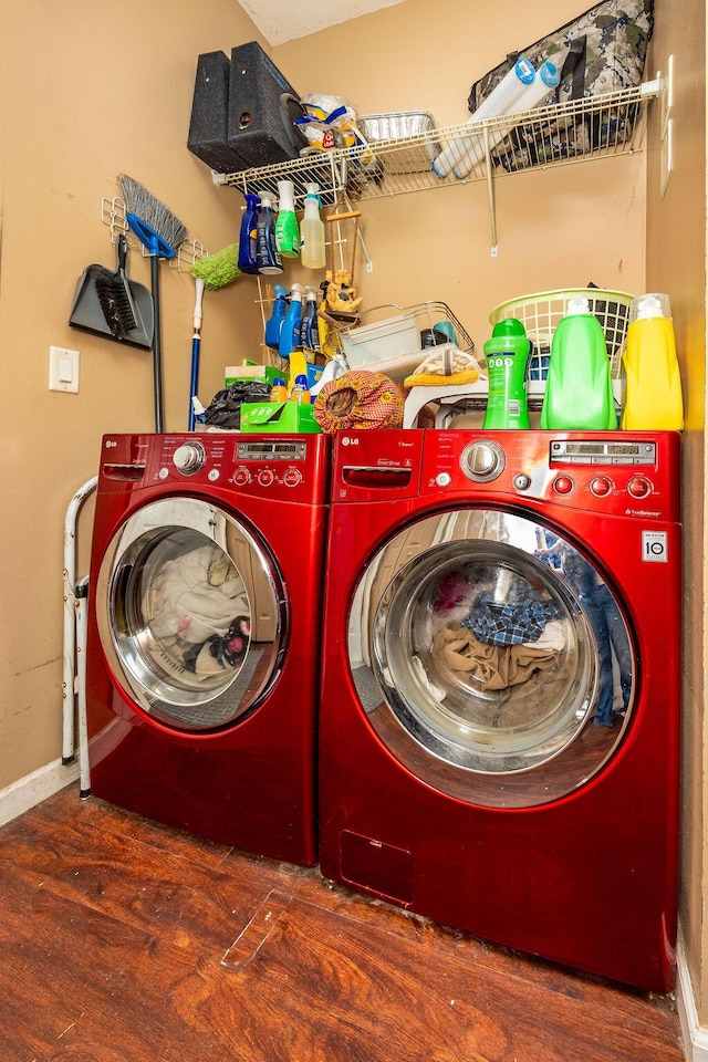 laundry area featuring baseboards, laundry area, dark wood finished floors, and washer and dryer