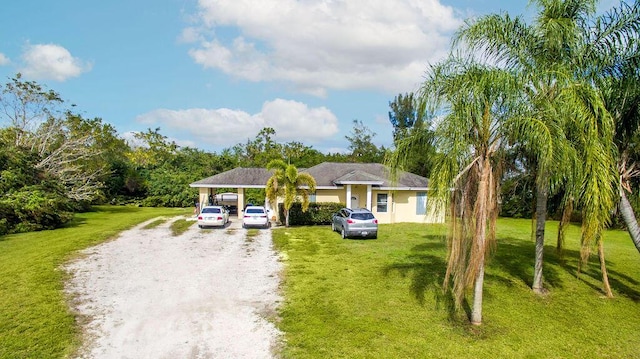 view of front of home featuring a carport, driveway, and a front lawn