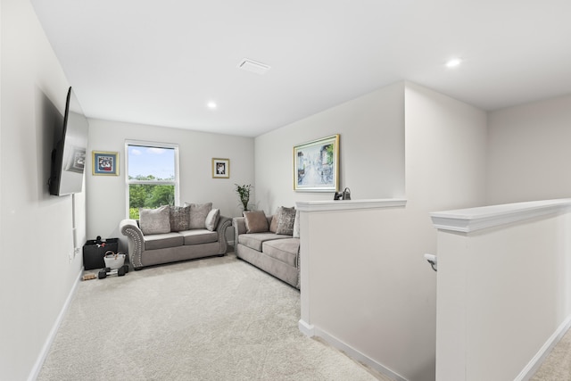 living area with recessed lighting, light colored carpet, and baseboards