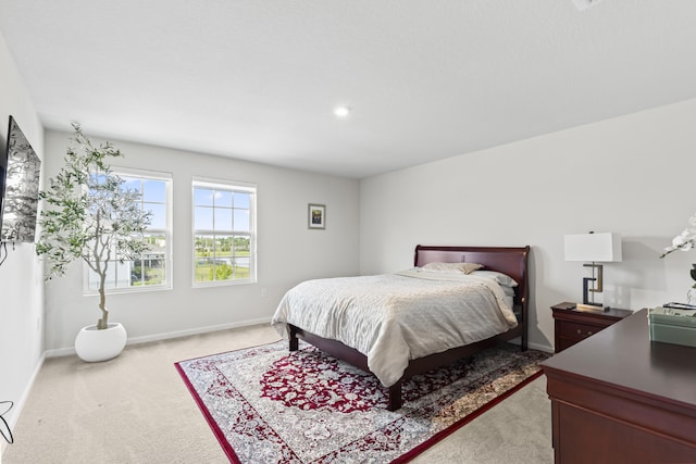 bedroom featuring baseboards and light colored carpet