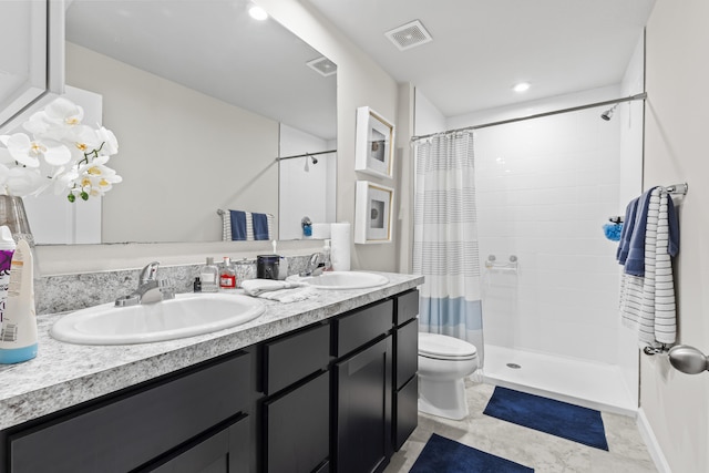 full bath with double vanity, visible vents, a tile shower, and a sink