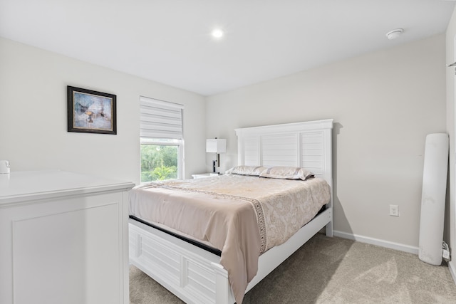 bedroom with light carpet and baseboards