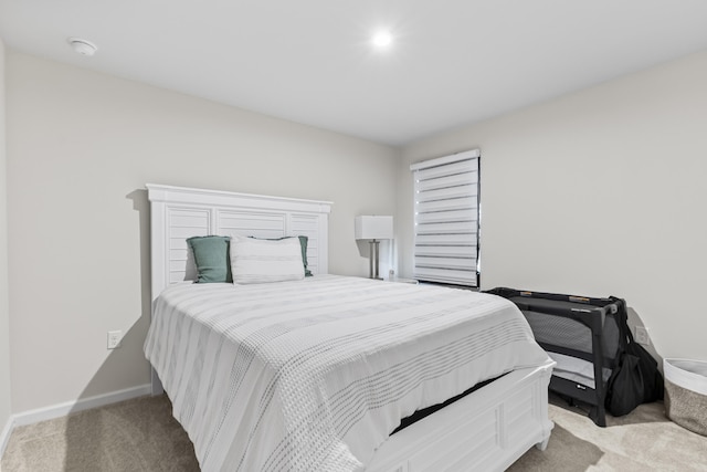 bedroom with light colored carpet and baseboards