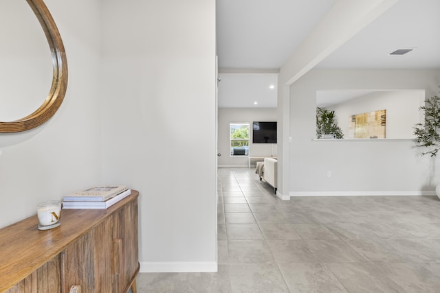 corridor featuring recessed lighting, visible vents, baseboards, and light tile patterned floors