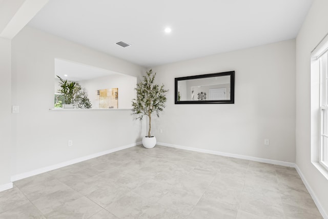 empty room with recessed lighting, visible vents, and baseboards