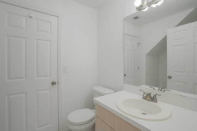 half bath featuring toilet, vanity, and visible vents