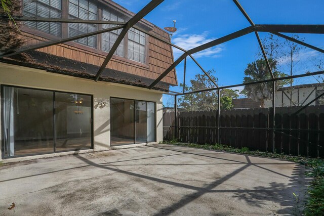 view of patio featuring a lanai and fence