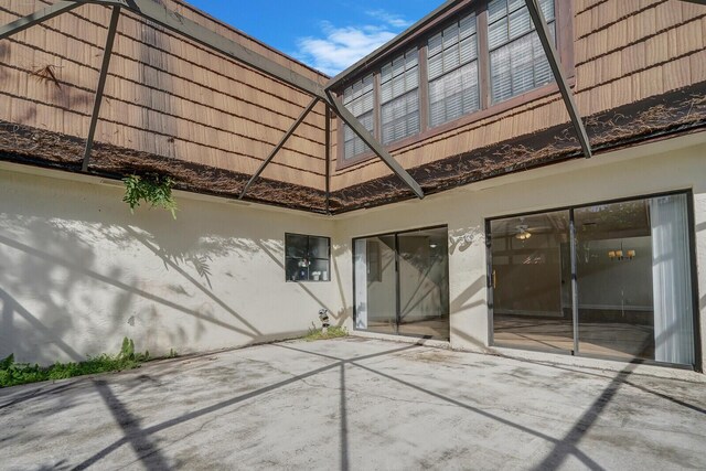 back of property featuring a patio, a tile roof, and stucco siding