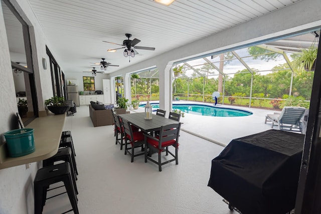 exterior space with ceiling fan, a lanai, a grill, an outdoor living space, and an outdoor pool