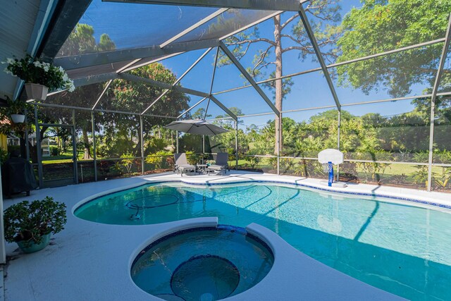 view of swimming pool with a patio area, a pool with connected hot tub, and glass enclosure