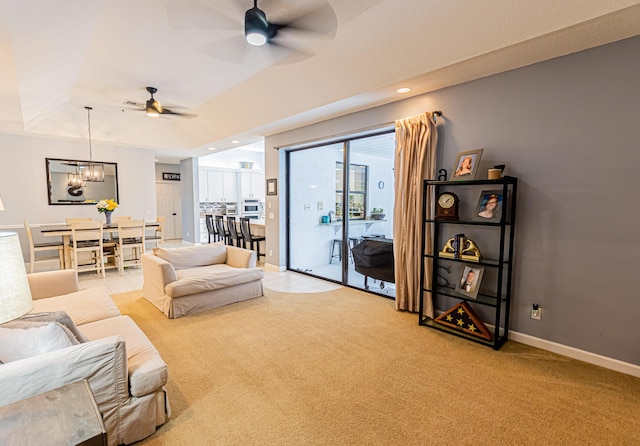 living room with light carpet, recessed lighting, ceiling fan with notable chandelier, and baseboards