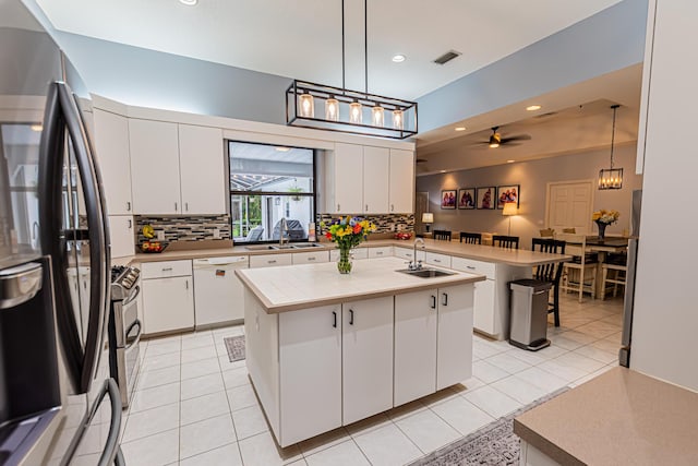 kitchen featuring freestanding refrigerator, visible vents, a sink, and white dishwasher