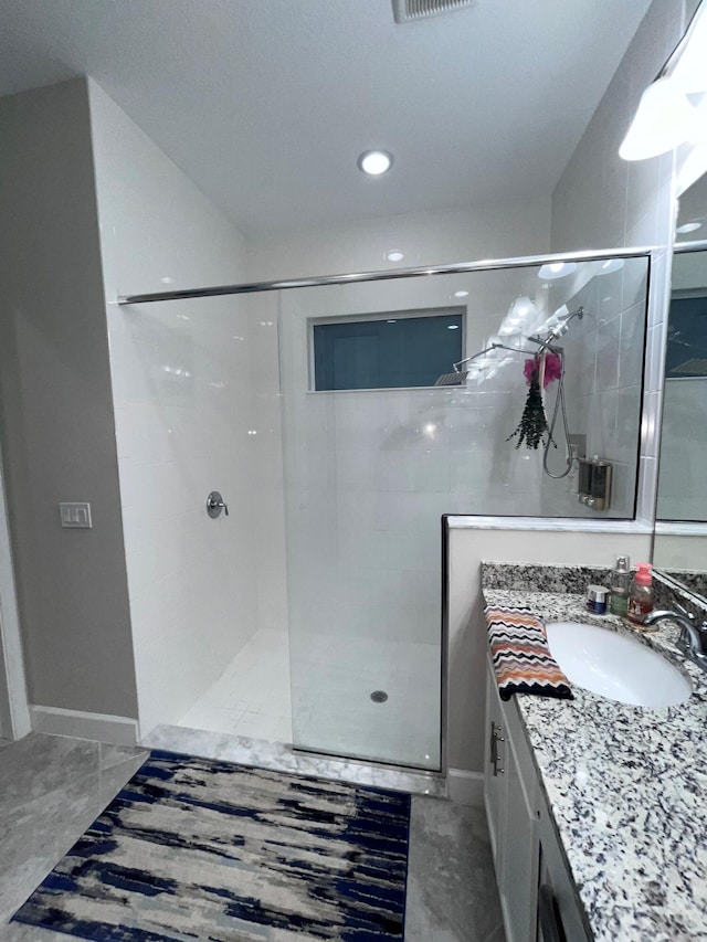 full bathroom featuring visible vents, walk in shower, vanity, and baseboards