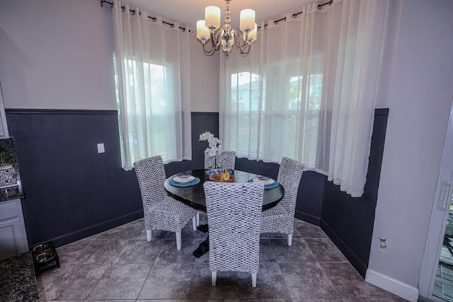 dining space featuring baseboards and a chandelier