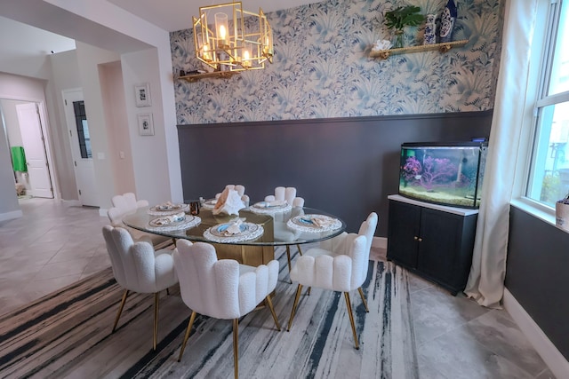 tiled dining area with wallpapered walls, a notable chandelier, baseboards, and a wainscoted wall