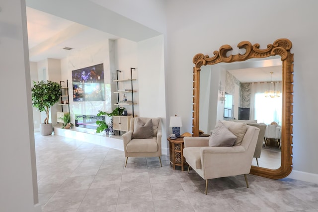 living area with a chandelier, visible vents, and baseboards