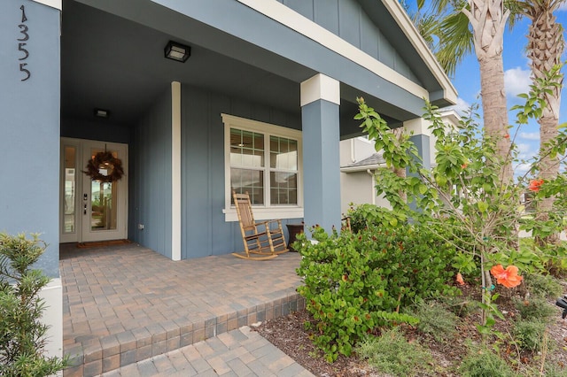 property entrance featuring covered porch and board and batten siding