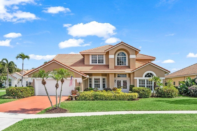 mediterranean / spanish home with french doors, a tile roof, stucco siding, a garage, and a front lawn