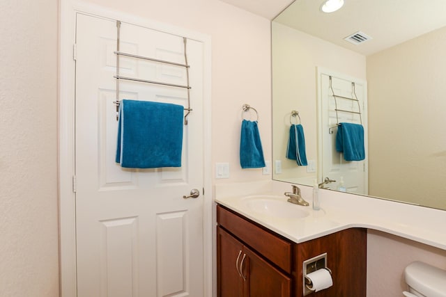 bathroom with toilet, recessed lighting, visible vents, and vanity