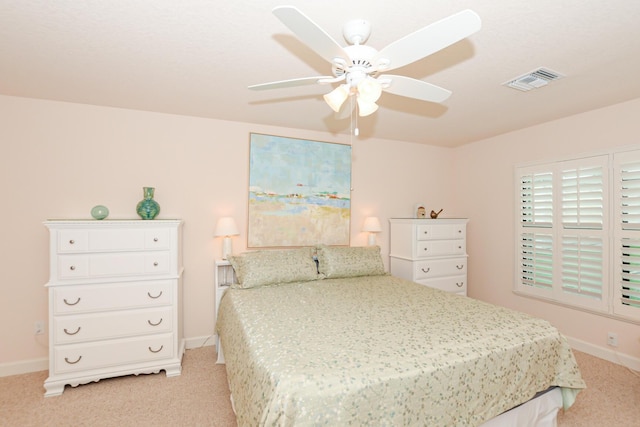 bedroom with a ceiling fan, light colored carpet, visible vents, and baseboards