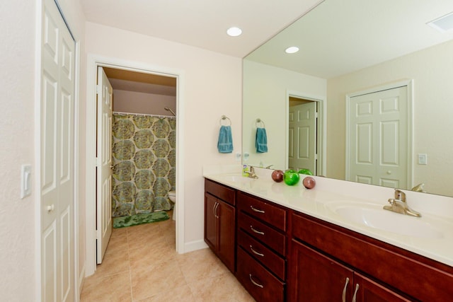 full bath with a closet, a sink, toilet, and double vanity