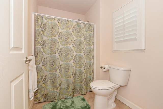 full bathroom featuring toilet, tile patterned flooring, and baseboards