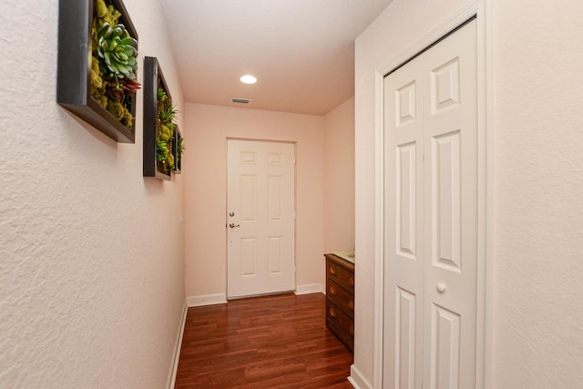 hallway featuring dark wood-style flooring, recessed lighting, visible vents, and baseboards