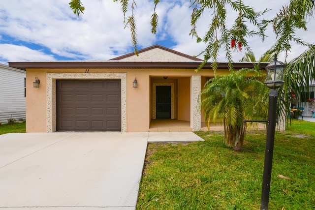 view of front of home featuring concrete driveway, a front yard, an attached garage, and stucco siding