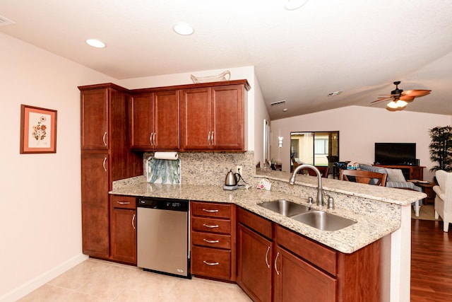 kitchen with lofted ceiling, a peninsula, a sink, open floor plan, and stainless steel dishwasher