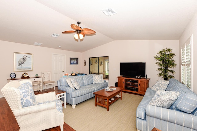 living area featuring light wood-style floors, visible vents, vaulted ceiling, and a ceiling fan