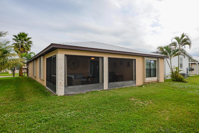 back of property featuring a lawn and a sunroom