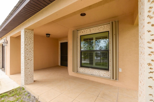 doorway to property featuring a patio area and stucco siding