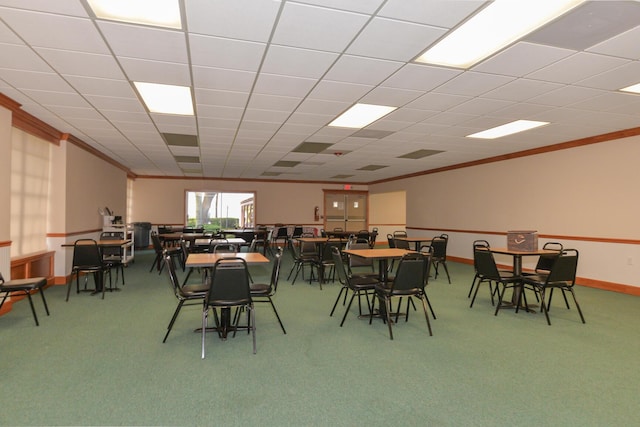 carpeted dining room featuring baseboards, a paneled ceiling, and crown molding