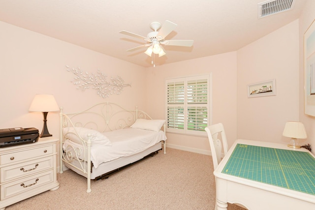 bedroom featuring a ceiling fan, visible vents, light carpet, and baseboards