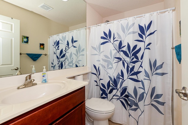 bathroom featuring visible vents, vanity, and toilet