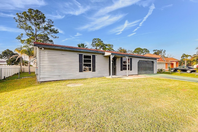 view of front facade with an attached garage, concrete driveway, a front yard, and fence